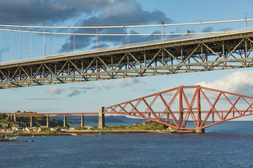 Older Forth Road bridge and the iconic Forth Rail Bridge in Edinburgh Scotland.