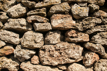 Old rural dry masonry stone wall closeup as stone background