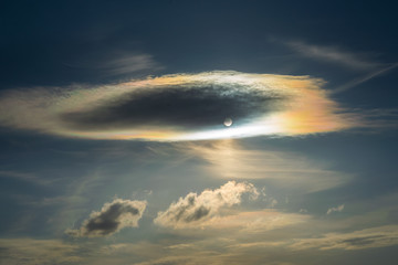 A colorful optical phenomenon called cloud iridescence or irisation that occurs in a cloud and appears in the general proximity of the sun. Here the irisation occurs in lenticular clouds.