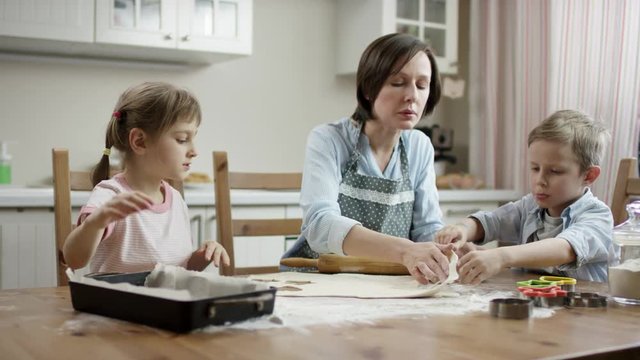 mom show how to lay-out biscuits in right way with focus on family