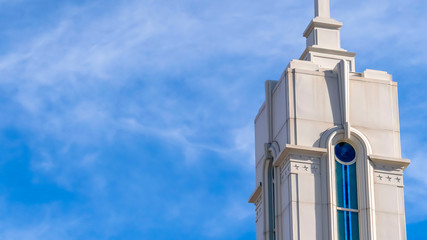 Clear Panorama Beautiful white steeple of a building against blue sky with wispy clouds