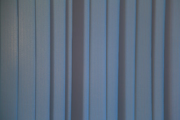 Textured surface of colored vertical textile blinds