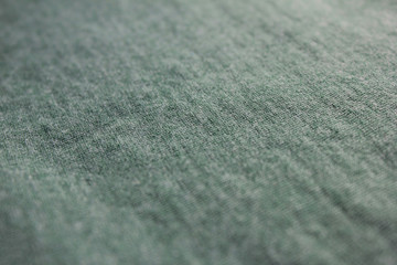 Pale soft green fabric background with selective focus, low angle view of cotton green shirt 
