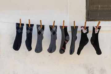 Unos calcetines colgados en una cuerda, sujetos con pinzas, después de la colada en un pueblo encalado de Italia