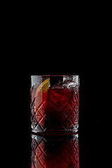 Negroni cocktail on a black background with reflection