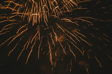 Close-up gold festive fireworks on a black background. Abstract holiday background