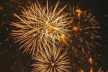 Close-up gold festive fireworks on a black background. Abstract holiday background