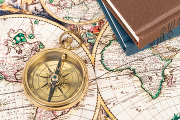 Fototapeta na wymiar Compass on vintage ancient map with book, concept for direction transportation and travel