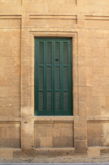 Fototapeta na wymiar Big shuttered window in stone wall 