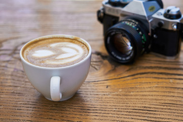 Delicious latte coffee and old camera