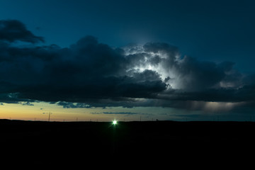 High based thunderstorm over the plains of North Dakota is illuminated by lightning during the...