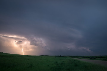 Fototapeta na wymiar Lightning from a supercell thunderstorm over the northern plains, USA during blue hour.