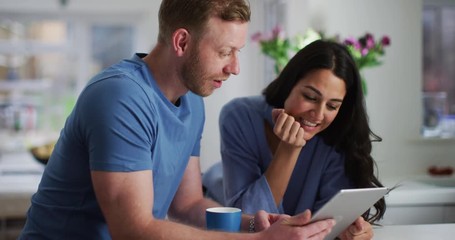 4K Attractive young couple surfing the web on tablet in stylish modern home. Slow motion. - Powered by Adobe