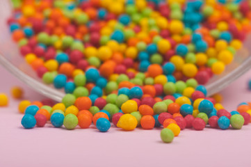 Multicolor candies in glass bowl. candy scattered for glass, macro photo
