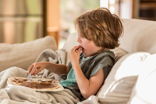5 year old boy eating a pancake breakfast at home