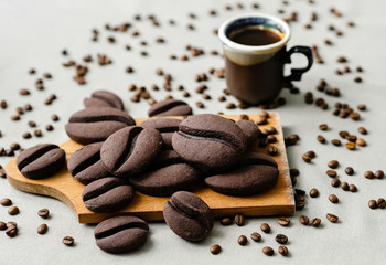 ginger biscuits with cocoa in the form of coffee beans on a wooden board on a gray background