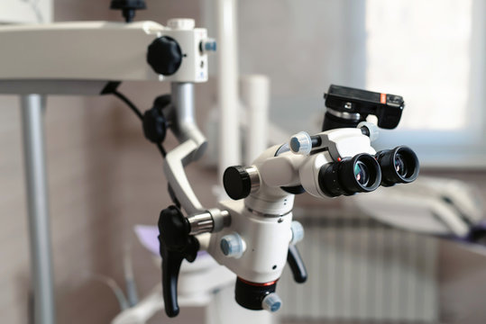 Dental binocular microscope on the background of modern dentistry. Medical equipment. operating microscope. with rotary double dental microscope white cabinet working room