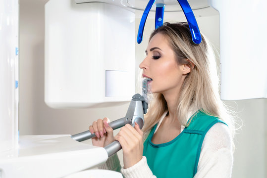 Young woman ready to computer 3d tomography of teeth and jaw in modern dental clinic