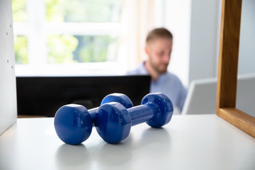 Dumbbells On Shelf And Man Working
