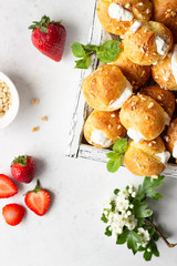 Profiteroles (choux à la crème) - French choux pastry balls filled with cottage cheese and cream with fresh strawberry, mint and cup of coffee.