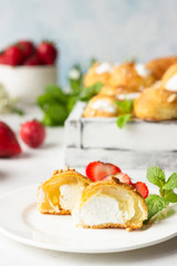 Profiteroles (choux à la crème) - French choux pastry balls filled with cottage cheese and cream with fresh strawberry, mint and cup of coffee.