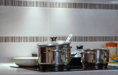 Fototapeta na wymiar Metal pots in the kitchen on the stove