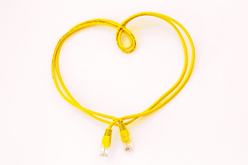 Yellow network cable folded in the shape of a heart isolated on white. Safer Internet Day. World Telecommunication and Information Society Day.