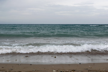 waves and wind on the sea beach with dramatic sky