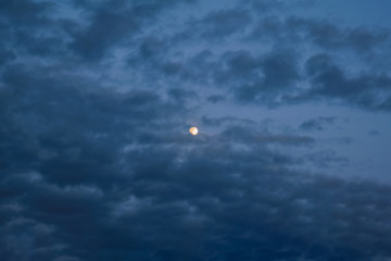 The sky with dark clouds illuminated by the setting sun