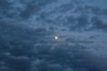 The sky with dark clouds illuminated by the setting sun