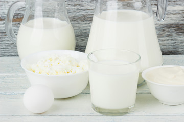 Different dairy products on the white wooden boards