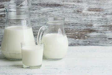 Different dairy products on the white wooden boards