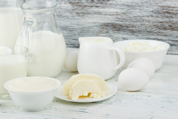Different dairy products on the white wooden boards