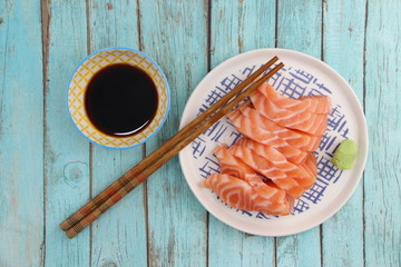 Sashimi saumon, baguettes et pot de sauce soja