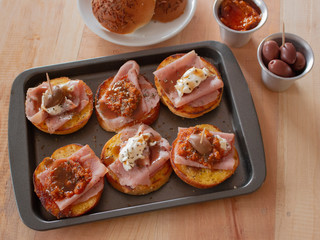 Spanish tapas of pastrami ham with tomato sauce and cream cheese with olives