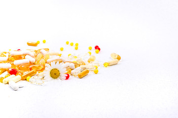 Scattered pills and vitamins on a white background. Health care and nutritional supplements.