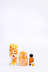 Pills and vitamins in a jar on a white background and liquid vitamins in a test tube. Free space for text. Nutritional supplements in capsules.