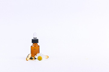 Capsule with a pipette for vitamins and oil on a white background. Free space for text.