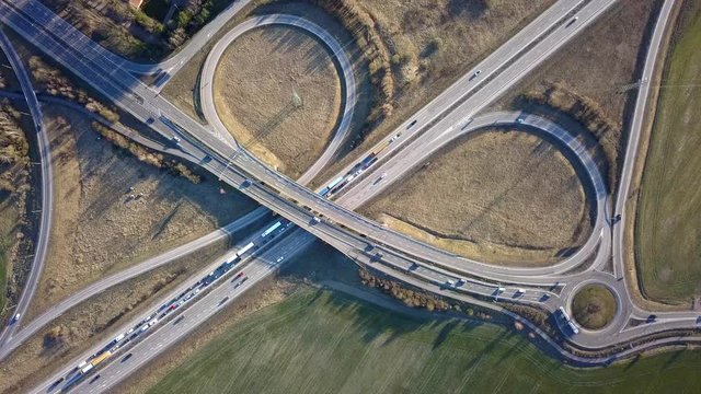 Aerial view of freeway intersection with moving traffic cars.