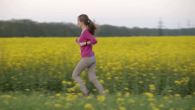 Young woman running in blooming fields.
