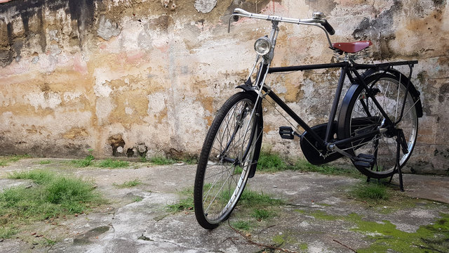 Retro vintage black bike on old brick wall.