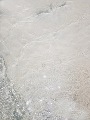 Beach sand Ocean waves with foam on the sand. Top view