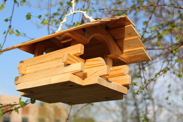 wooden bird feeder on a tree branch
