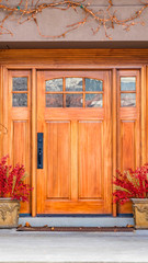 Vertical Brown wooden front door with decorative glass panels at the entrance of a home