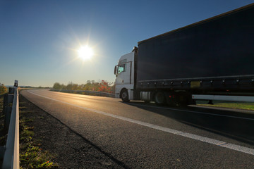 Truck transport on the road at sunset and cargo