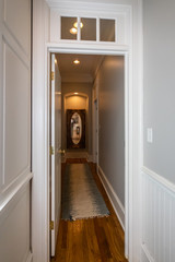 Long Interior Hallway in Colonial traditional home with mirror at the end