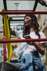 Young pretty smiling hipster girl with skateboard