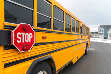 Exterior view of a yellow school bus with a red stop sign and signal lights