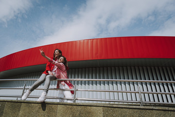 Happy female friends having fun on city ramp rails
