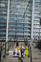Fototapeta premium Two female skaters sitting on stairs with coffee